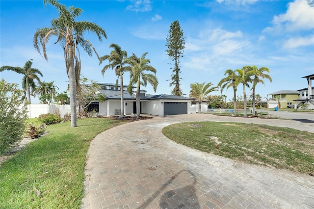 ranch-style house with a garage and a front lawn