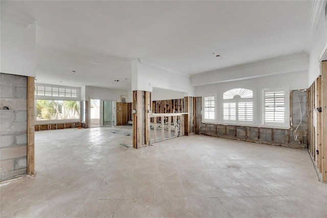 unfurnished living room with ornamental molding