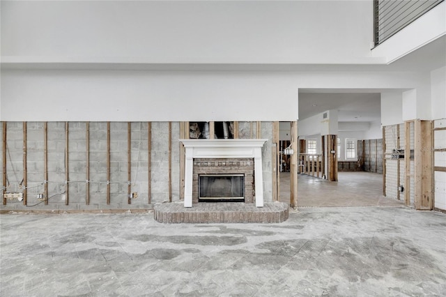 unfurnished living room with a high ceiling and a fireplace