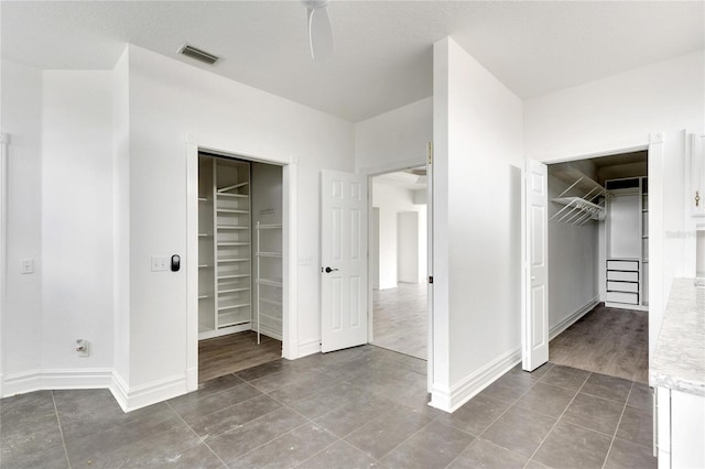 unfurnished bedroom featuring a closet, a textured ceiling, hardwood / wood-style flooring, and ceiling fan