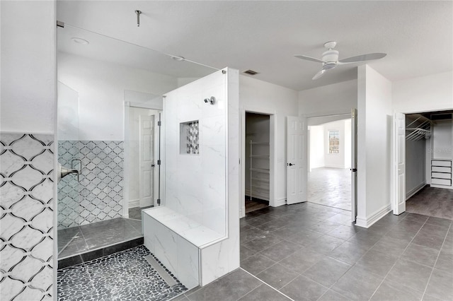 bathroom with ceiling fan, tile patterned flooring, and a tile shower