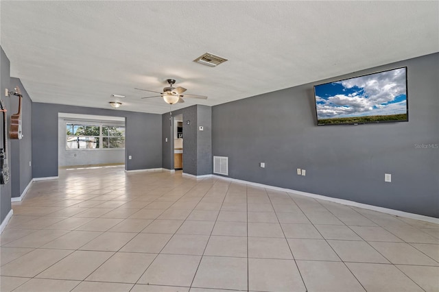 tiled spare room with ceiling fan and a textured ceiling