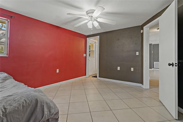 tiled bedroom with ceiling fan and a textured ceiling