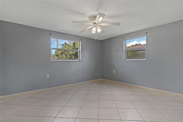 spare room with ceiling fan and light tile patterned floors