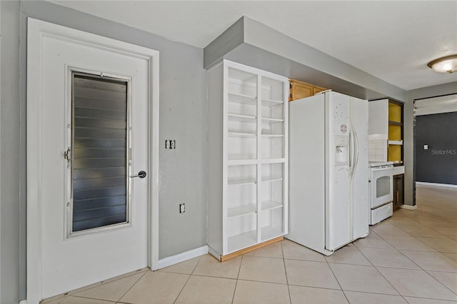 kitchen with white appliances, a textured ceiling, and light tile patterned floors