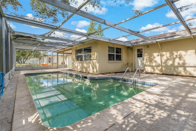 view of swimming pool featuring a patio and a lanai