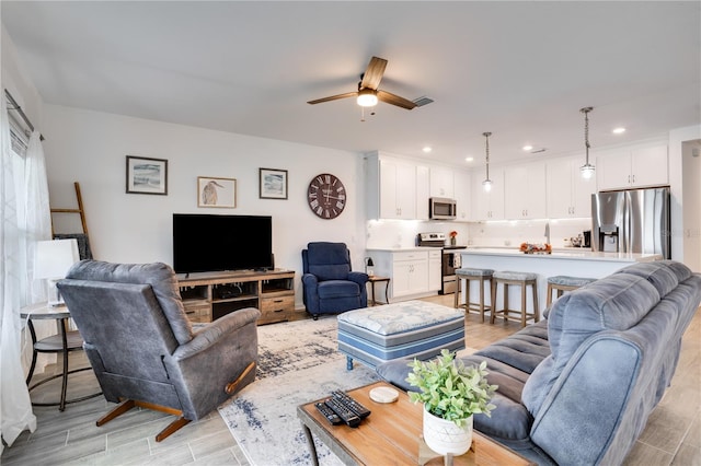 living room featuring light hardwood / wood-style floors and ceiling fan