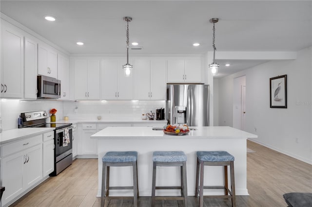 kitchen featuring white cabinets, stainless steel appliances, and a center island