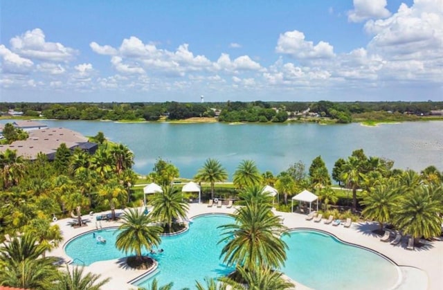 view of swimming pool with a patio area and a water view