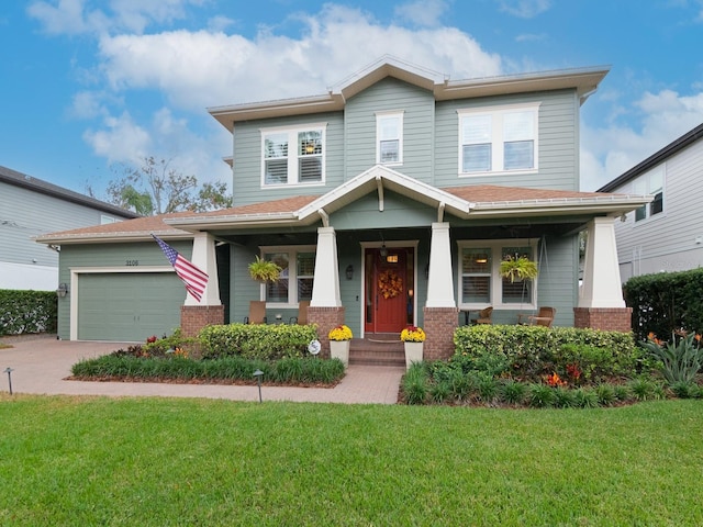 view of front facade with a porch, a front yard, and a garage