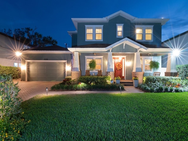 view of front of property with a garage, a yard, brick siding, and decorative driveway