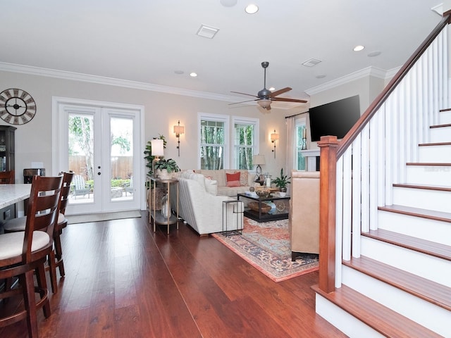 living area featuring dark wood-type flooring, french doors, stairway, and a wealth of natural light