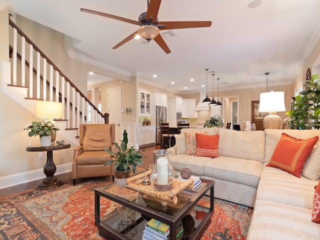 living room with baseboards, visible vents, wood finished floors, and ornamental molding