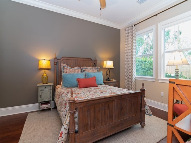 bedroom featuring visible vents, crown molding, baseboards, and wood finished floors