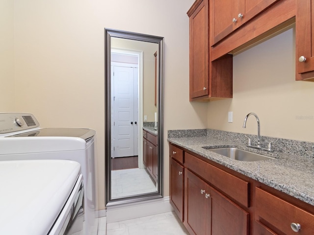 laundry area with washing machine and clothes dryer, a sink, and cabinet space