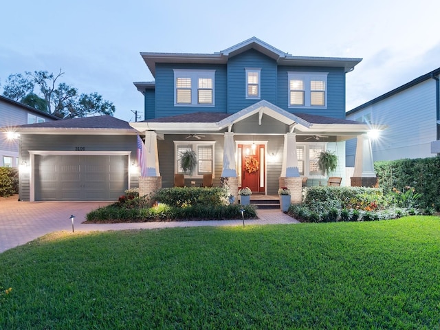 craftsman-style home featuring an attached garage, a porch, decorative driveway, and a front yard