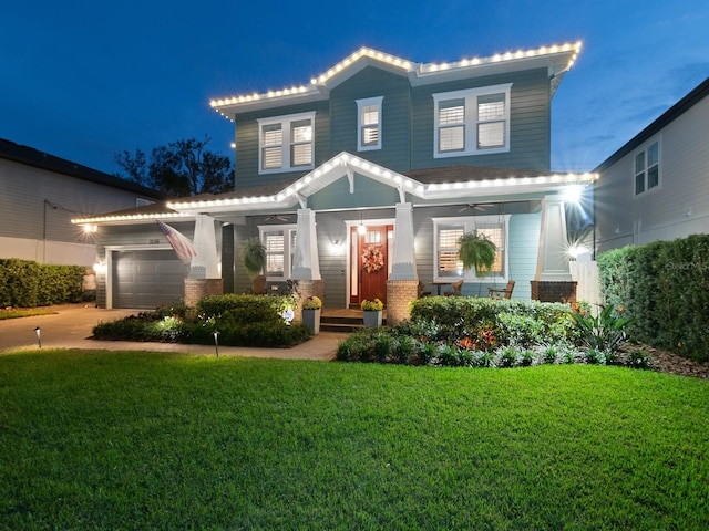 view of front of home with a garage, driveway, a front yard, a porch, and brick siding