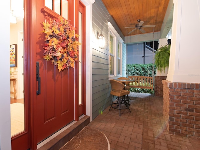 entrance to property featuring covered porch and a ceiling fan