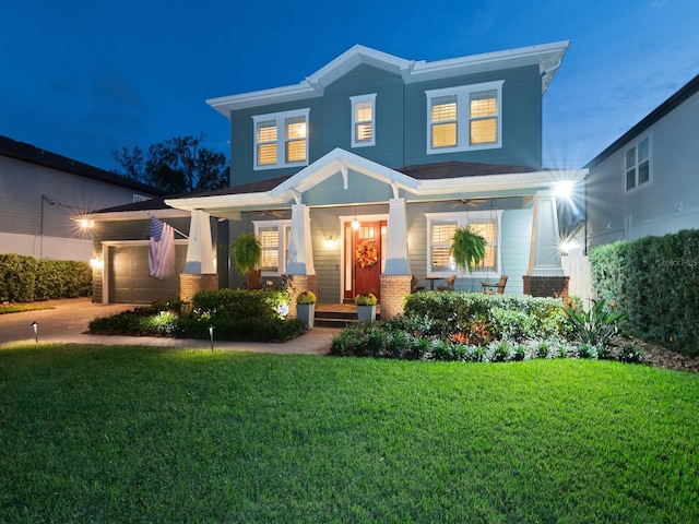 view of front of property featuring brick siding, a porch, a lawn, a garage, and driveway