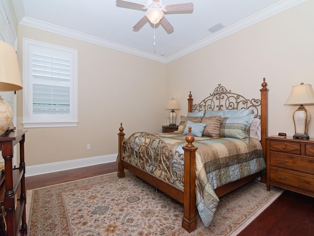 bedroom with baseboards, wood finished floors, visible vents, and crown molding