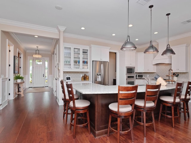 kitchen with stainless steel appliances, visible vents, white cabinetry, dark wood finished floors, and glass insert cabinets