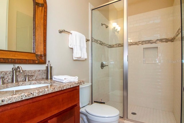 full bathroom with a shower stall, toilet, and vanity