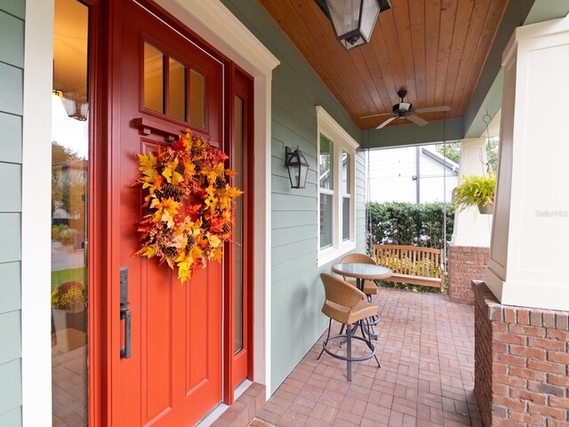 entrance to property featuring covered porch and ceiling fan