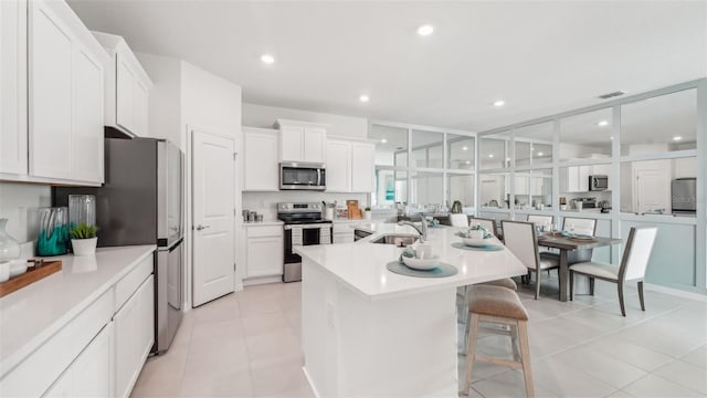 kitchen featuring stainless steel appliances, a kitchen breakfast bar, and white cabinetry