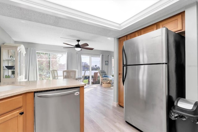 kitchen with light hardwood / wood-style floors, appliances with stainless steel finishes, a textured ceiling, and ceiling fan