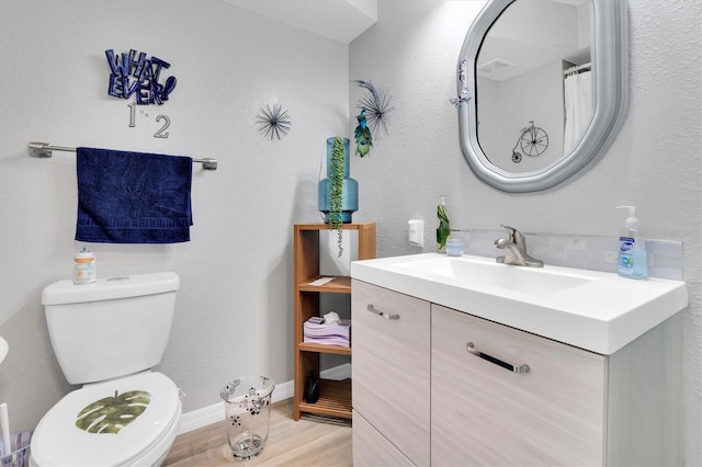 bathroom with hardwood / wood-style floors, vanity, and toilet