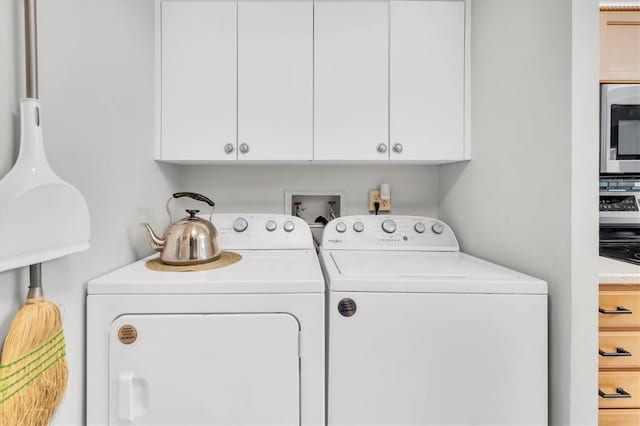 clothes washing area featuring cabinets and washing machine and clothes dryer