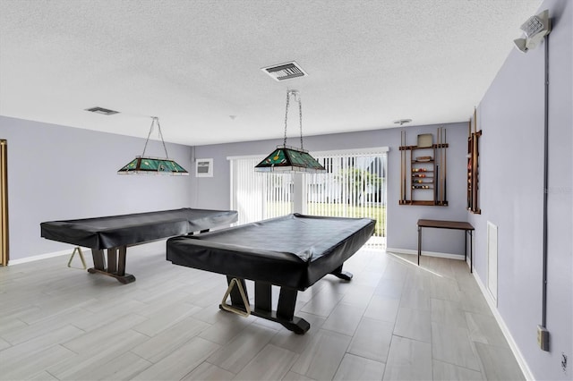 recreation room featuring billiards, light hardwood / wood-style floors, and a textured ceiling