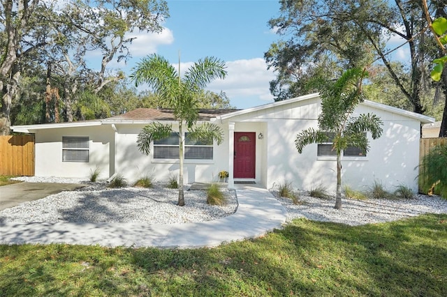 single story home featuring stucco siding and fence