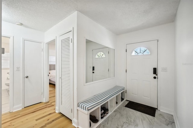 entryway featuring light hardwood / wood-style floors and a textured ceiling