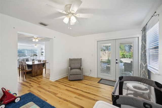 living area with french doors, hardwood / wood-style flooring, and ceiling fan