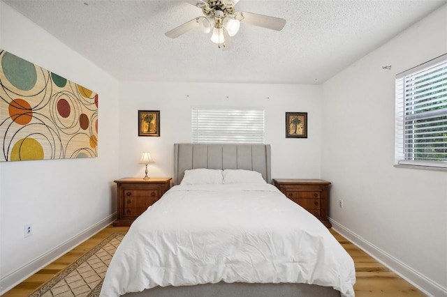 bedroom featuring ceiling fan, a textured ceiling, and light hardwood / wood-style flooring