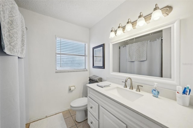 bathroom with toilet, vanity, a textured ceiling, and tile patterned flooring