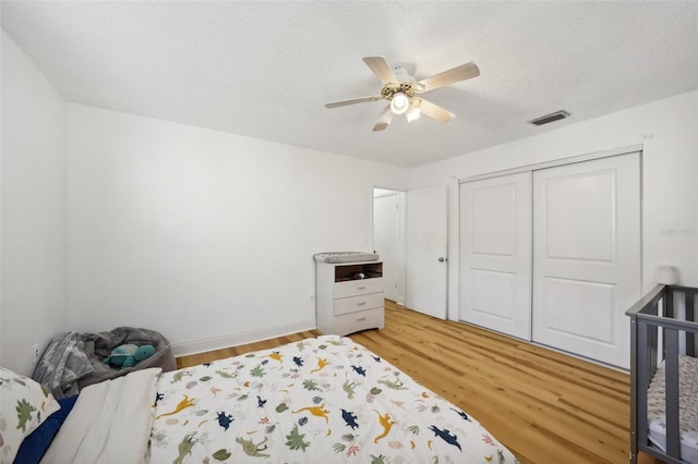 bedroom featuring hardwood / wood-style floors, ceiling fan, a textured ceiling, and a closet