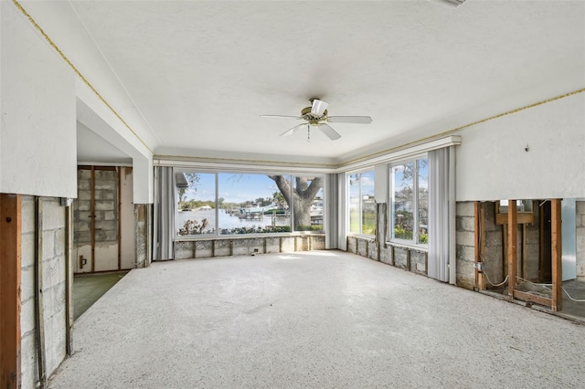 living room featuring ceiling fan and a water view