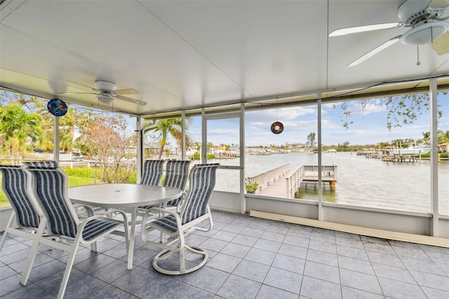 sunroom with ceiling fan, a water view, and a wealth of natural light