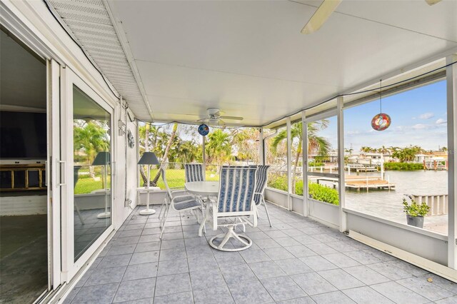 unfurnished sunroom with a water view and ceiling fan