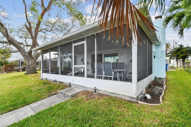 view of side of property with a lawn and a sunroom