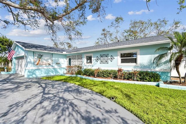 single story home featuring a garage and a front yard