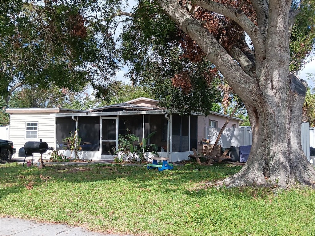 back of house with a sunroom and a yard