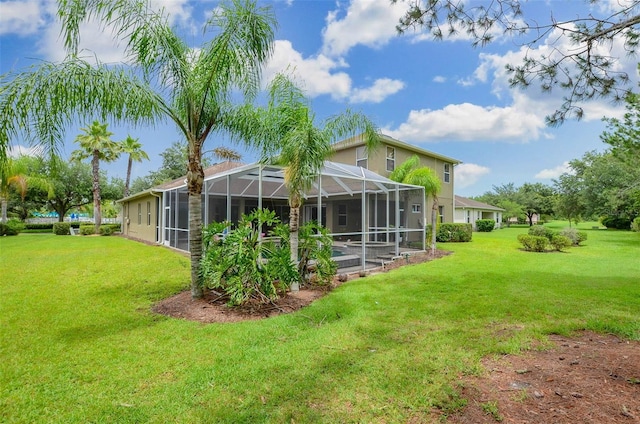 rear view of house featuring a yard and glass enclosure