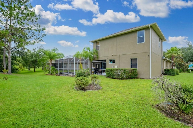 rear view of property with a yard and glass enclosure