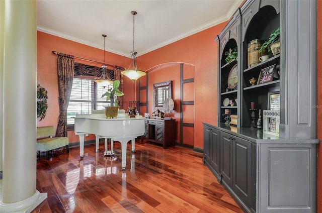 interior space featuring dark wood-type flooring, decorative columns, and ornamental molding