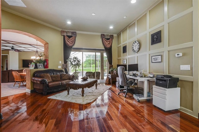 office space with built in features, hardwood / wood-style floors, crown molding, and ceiling fan with notable chandelier