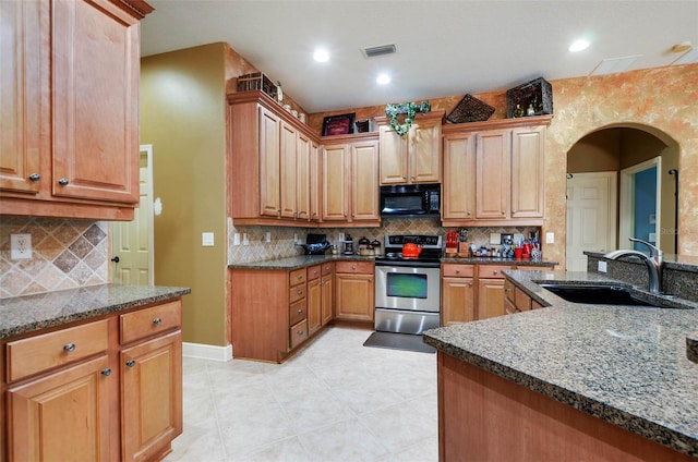 kitchen with dark stone countertops, sink, tasteful backsplash, and electric range