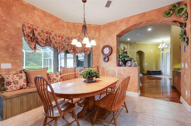 dining space featuring a chandelier, light hardwood / wood-style flooring, and ornamental molding